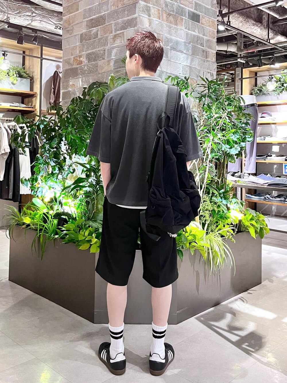 ブラック系のバックパック/リュック、ブラック系のスラックス、ホワイト系のタンクトップを着用したメンズの夏コーディネートの4枚目の写真