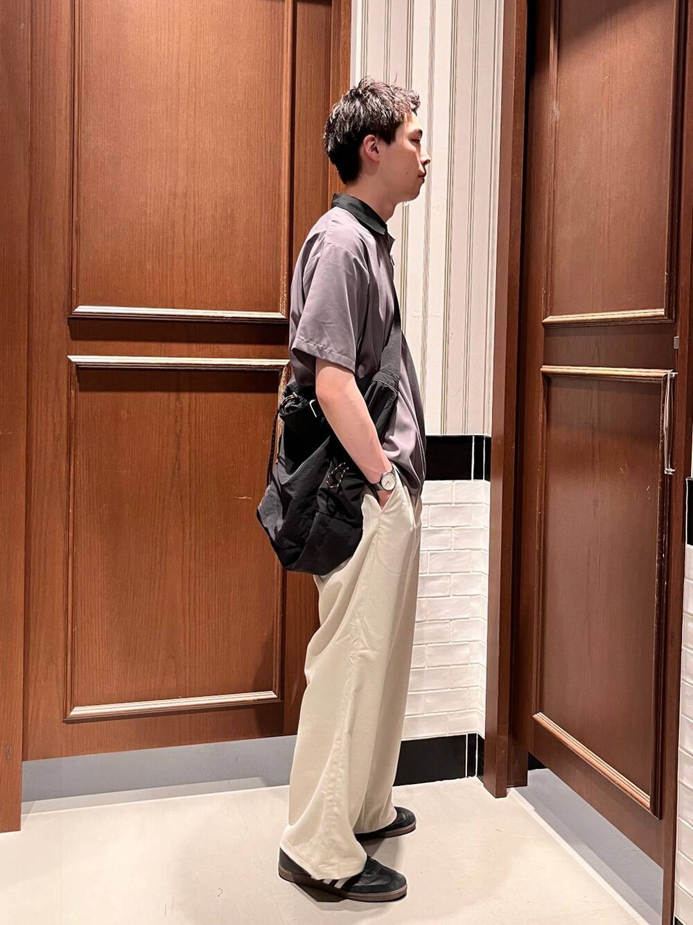 ホワイト系のスラックス、ブラック系のショルダーバッグ、グレー系のシャツ/ブラウスを着用したメンズの夏コーディネートの5枚目の写真
