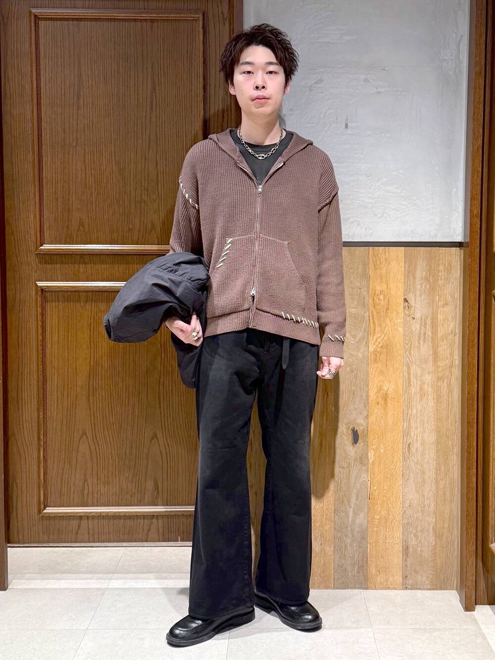 ブラック系のデニムパンツ、ブラック系のモッズコート、ブラウン系のニット/セーターを着用したメンズの冬コーディネートの7枚目の写真