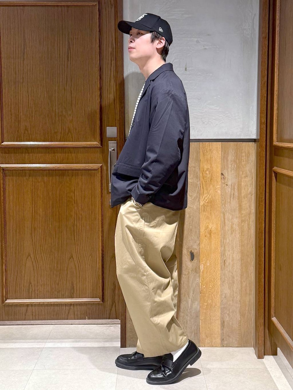 ブルー系のテーラードジャケット、ホワイト系のTシャツ/カットソー、ベージュ系のチノパンツを着用したメンズの冬コーディネートの2枚目の写真