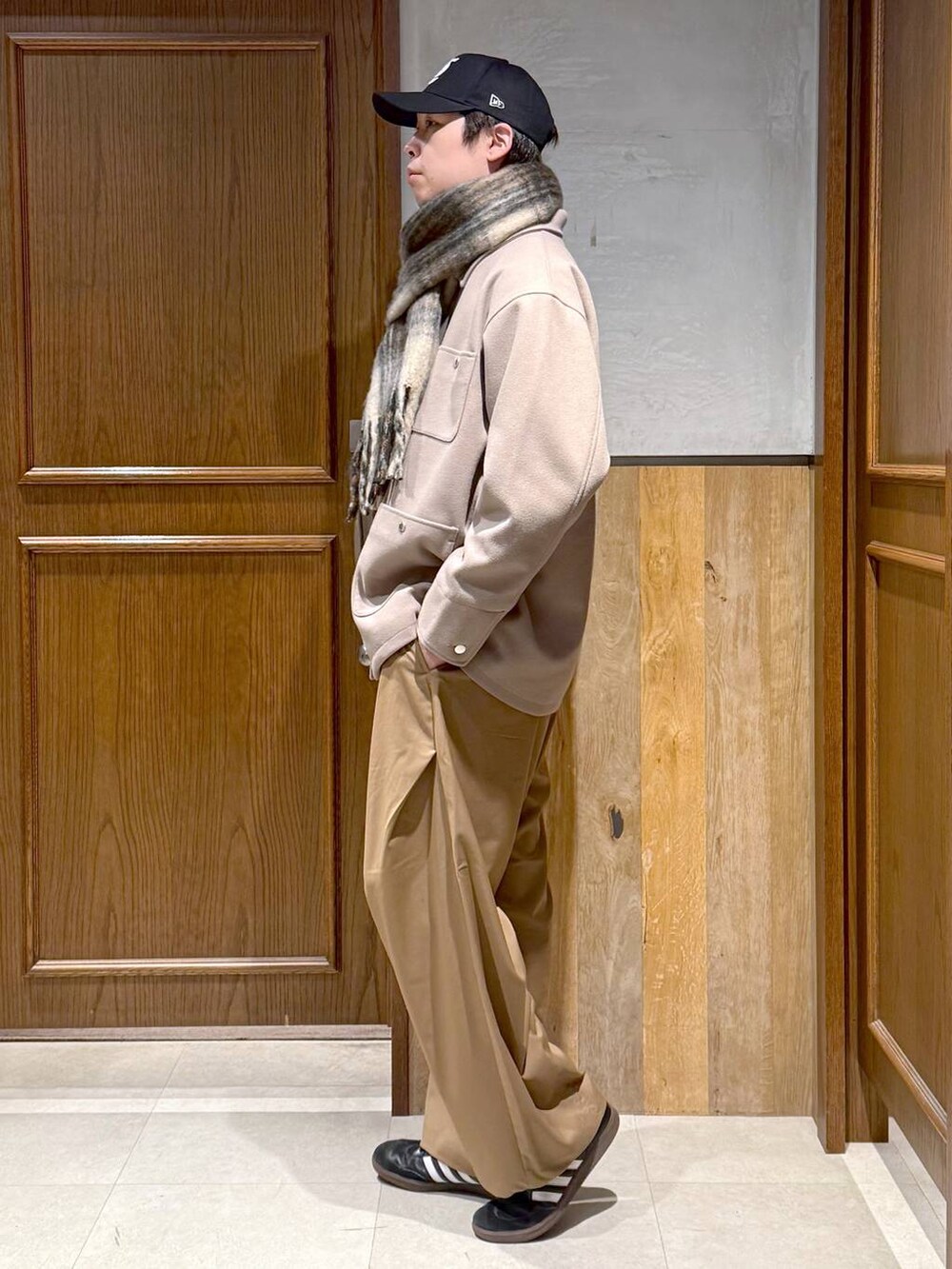 ホワイト系のニット/セーター、ベージュ系のブルゾン、ベージュ系のスラックスを着用したメンズの冬コーディネートの3枚目の写真