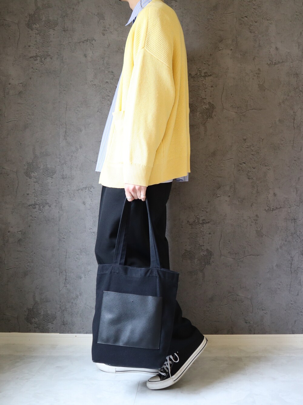 ブルー系のシャツ/ブラウス、イエロー系のニット/セーター、ブラック系のスラックスを着用したメンズの春コーディネートの4枚目の写真