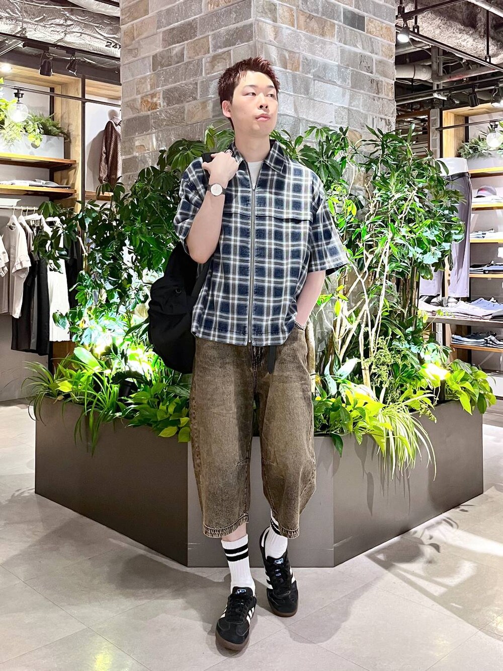 ブラック系のバックパック/リュック、ホワイト系のタンクトップ、グレー系のデニムパンツを着用したメンズの夏コーディネートの4枚目の写真