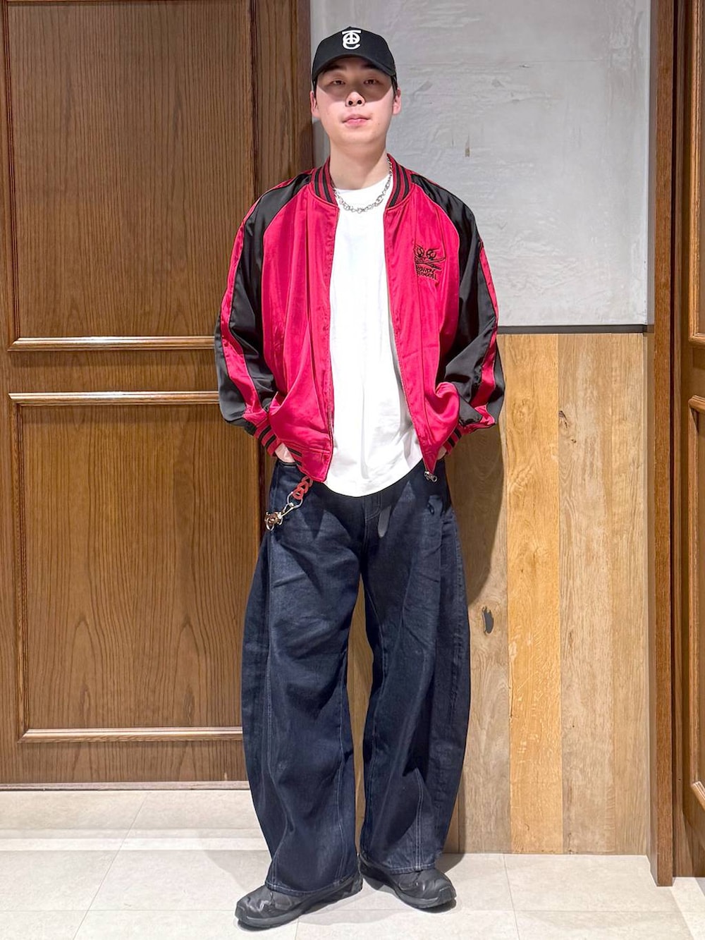 ホワイト系のTシャツ/カットソー、レッド系のスカジャン、ブルー系のデニムパンツを着用したメンズの春コーディネートの6枚目の写真