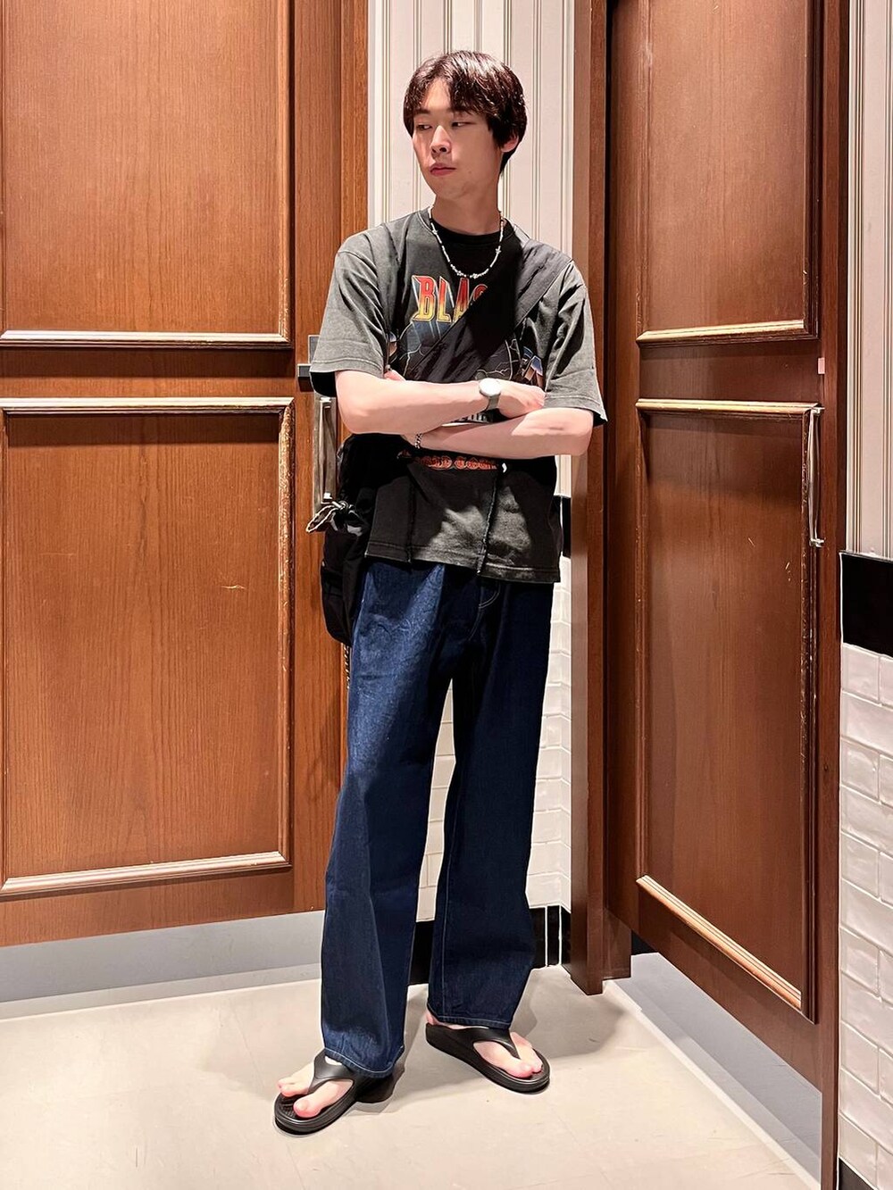 ブラック系のサンダル、ブルー系のデニムパンツ、ブラック系のショルダーバッグを着用したメンズの夏コーディネートの6枚目の写真