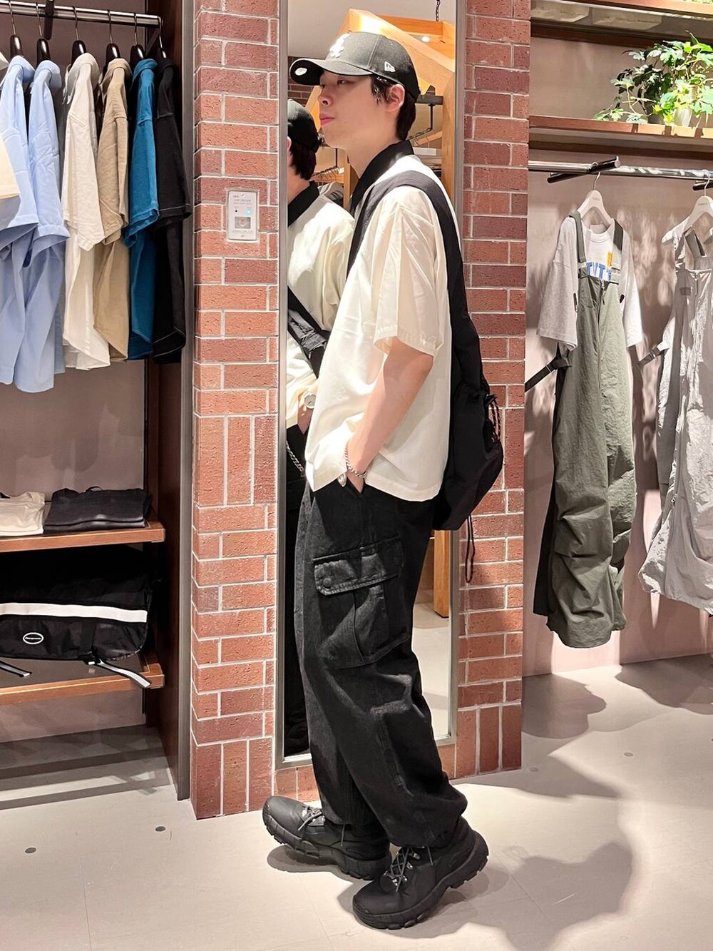 グレー系のデニムパンツ、ブラック系のショルダーバッグ、ホワイト系のシャツ/ブラウスを着用したメンズの夏コーディネートの3枚目の写真