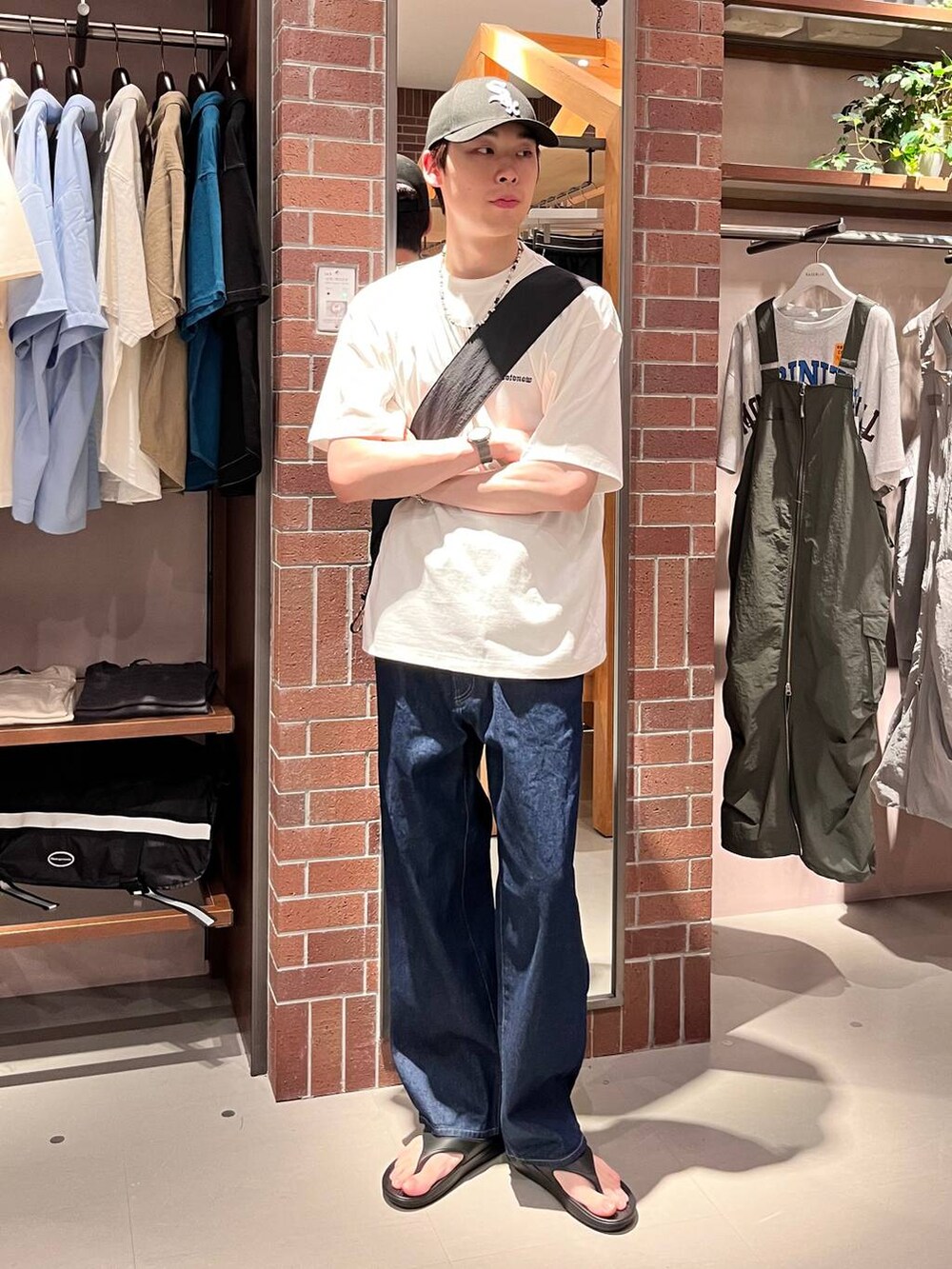 ブルー系のデニムパンツ、ブラック系のショルダーバッグ、ホワイト系のTシャツ/カットソーを着用したメンズの夏コーディネートの5枚目の写真