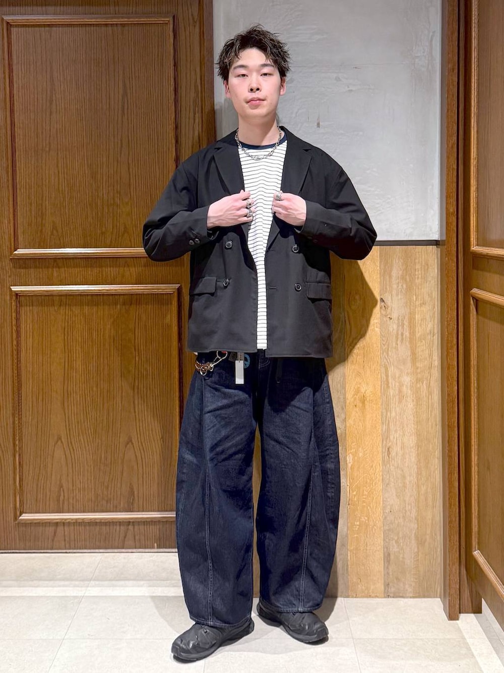 ブラック系のテーラードジャケット、ホワイト系のTシャツ/カットソー、ブルー系のデニムパンツを着用したメンズの春コーディネートの2枚目の写真