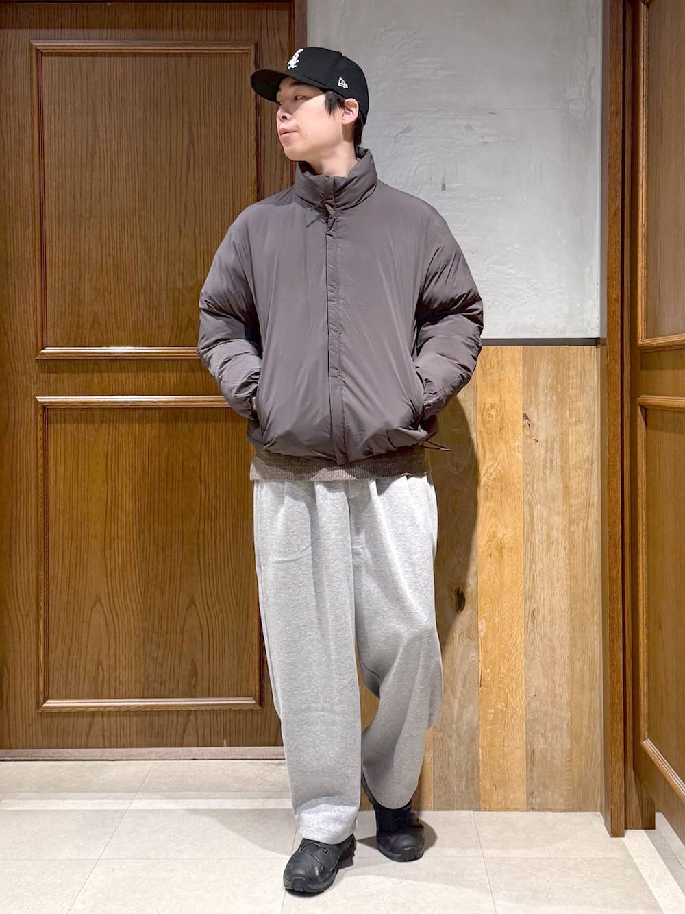 グレー系のダウンジャケット/コート、ベージュ系のポロシャツ、グレー系のスウェットパンツを着用したメンズの冬コーディネートの4枚目の写真