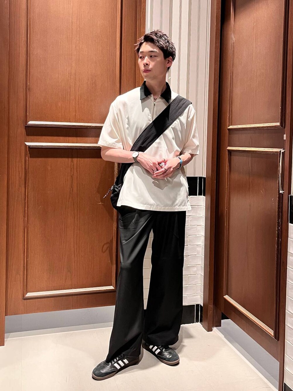 ブラック系のスラックス、ブラック系のショルダーバッグ、ホワイト系のシャツ/ブラウスを着用したメンズの夏コーディネートの6枚目の写真