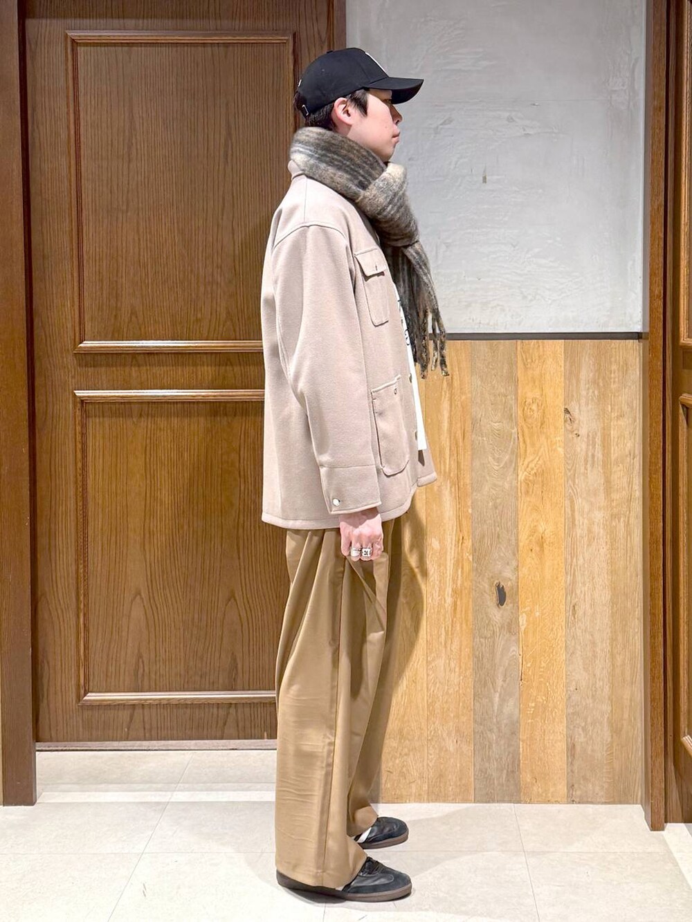 ホワイト系のニット/セーター、ベージュ系のブルゾン、ベージュ系のスラックスを着用したメンズの冬コーディネートの5枚目の写真