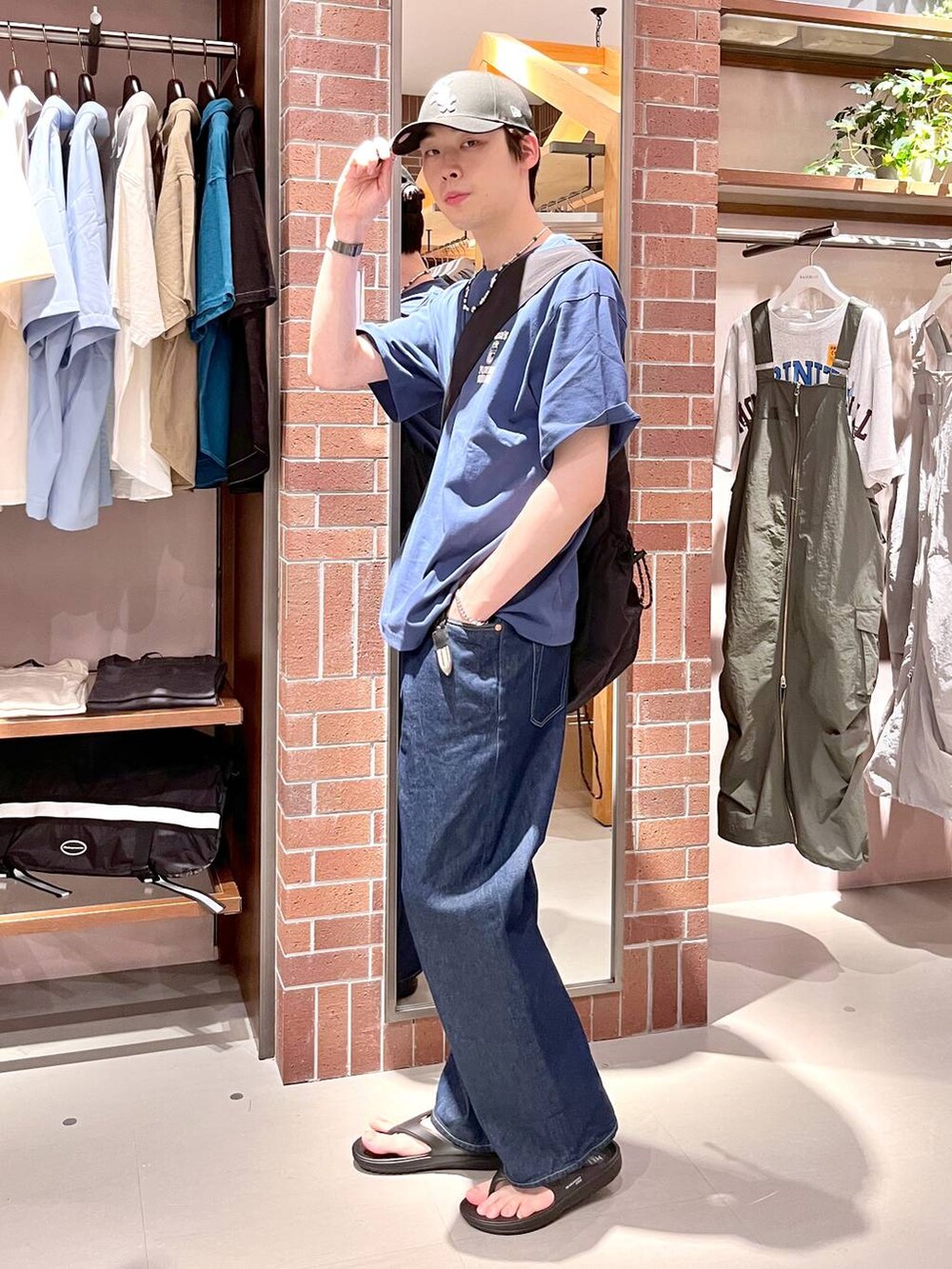 ブルー系のデニムパンツ、ブラック系のショルダーバッグ、ブルー系のTシャツ/カットソーを着用したメンズの夏コーディネートの2枚目の写真