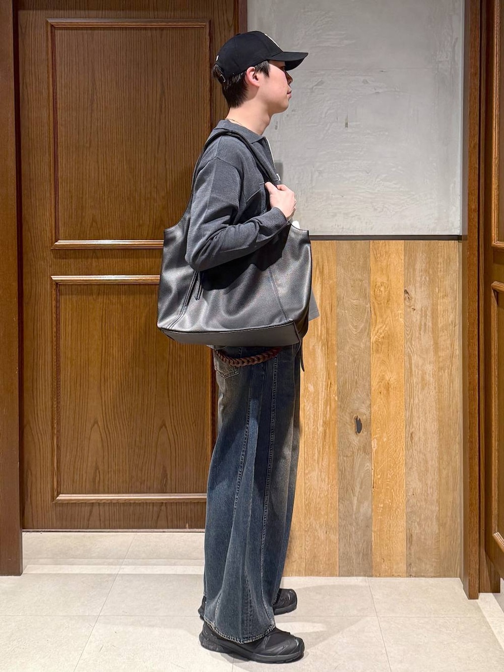 ブラック系のトートバッグ、ブルー系のデニムパンツ、グレー系のTシャツ/カットソーを着用したメンズの春コーディネートの3枚目の写真