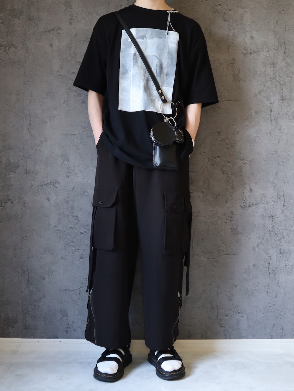 ブラック系のTシャツ/カットソー、ブラック系のカーゴパンツ、ブラック系のサンダルを着用したメンズの夏コーディネートの2枚目の写真