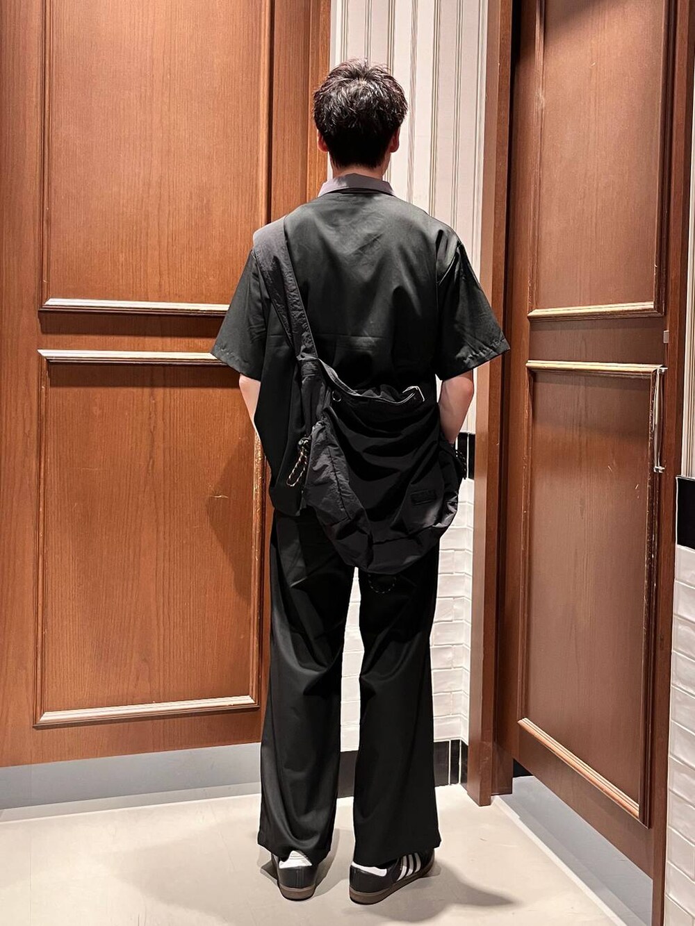 ブラック系のスラックス、ブラック系のショルダーバッグ、ブラック系のシャツ/ブラウスを着用したメンズの夏コーディネートの4枚目の写真