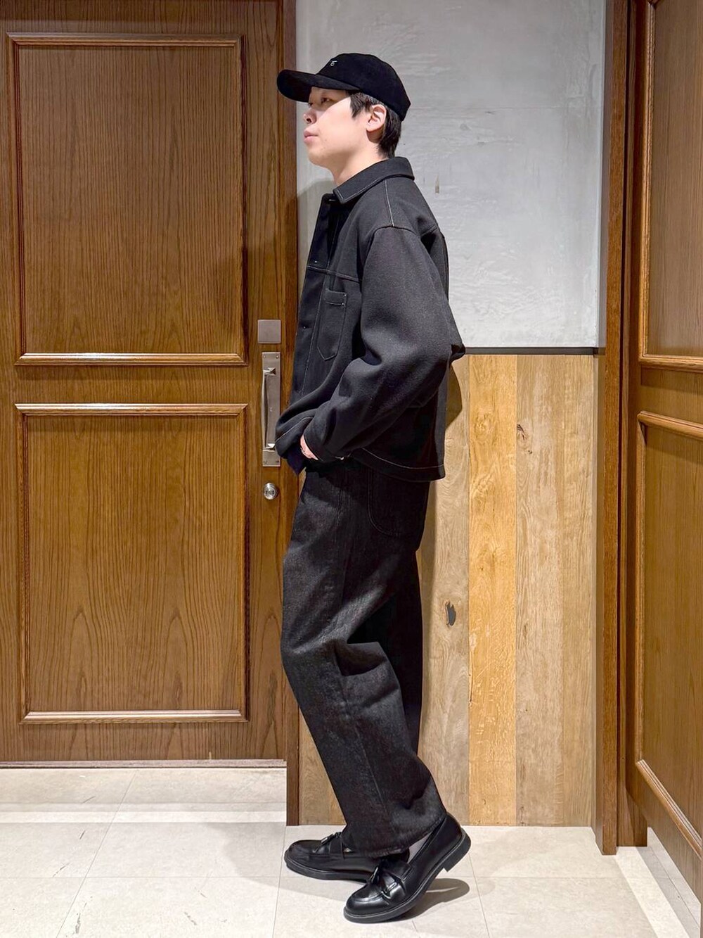 ブラック系のブルゾン、ブラック系のデニムパンツ、ブルー系のニット/セーターを着用したメンズの冬コーディネートの4枚目の写真