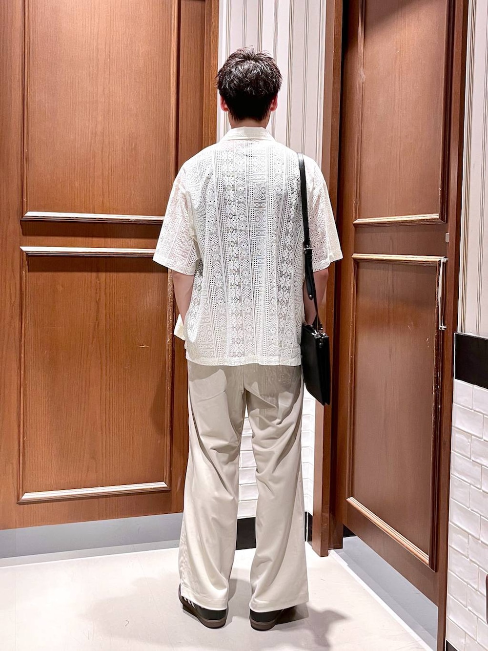 ホワイト系のスラックス、ブラック系のショルダーバッグ、ホワイト系のシャツ/ブラウスを着用したメンズの夏コーディネートの4枚目の写真