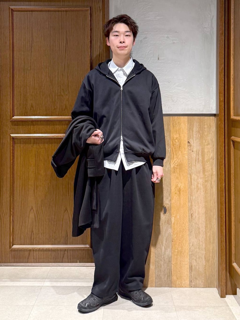 ブラック系のトレンチコート、ブルー系のシャツ/ブラウス、ブラック系のパーカーを着用したメンズの秋コーディネートの3枚目の写真