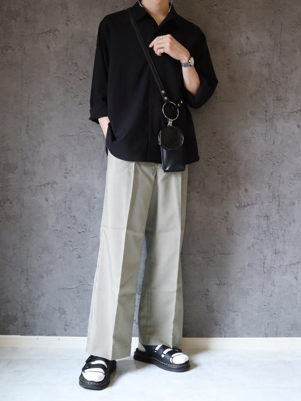ブラック系のシャツ/ブラウス、ブラック系のショルダーバッグ、ベージュ系のスラックスを着用したメンズの夏コーディネートの3枚目の写真