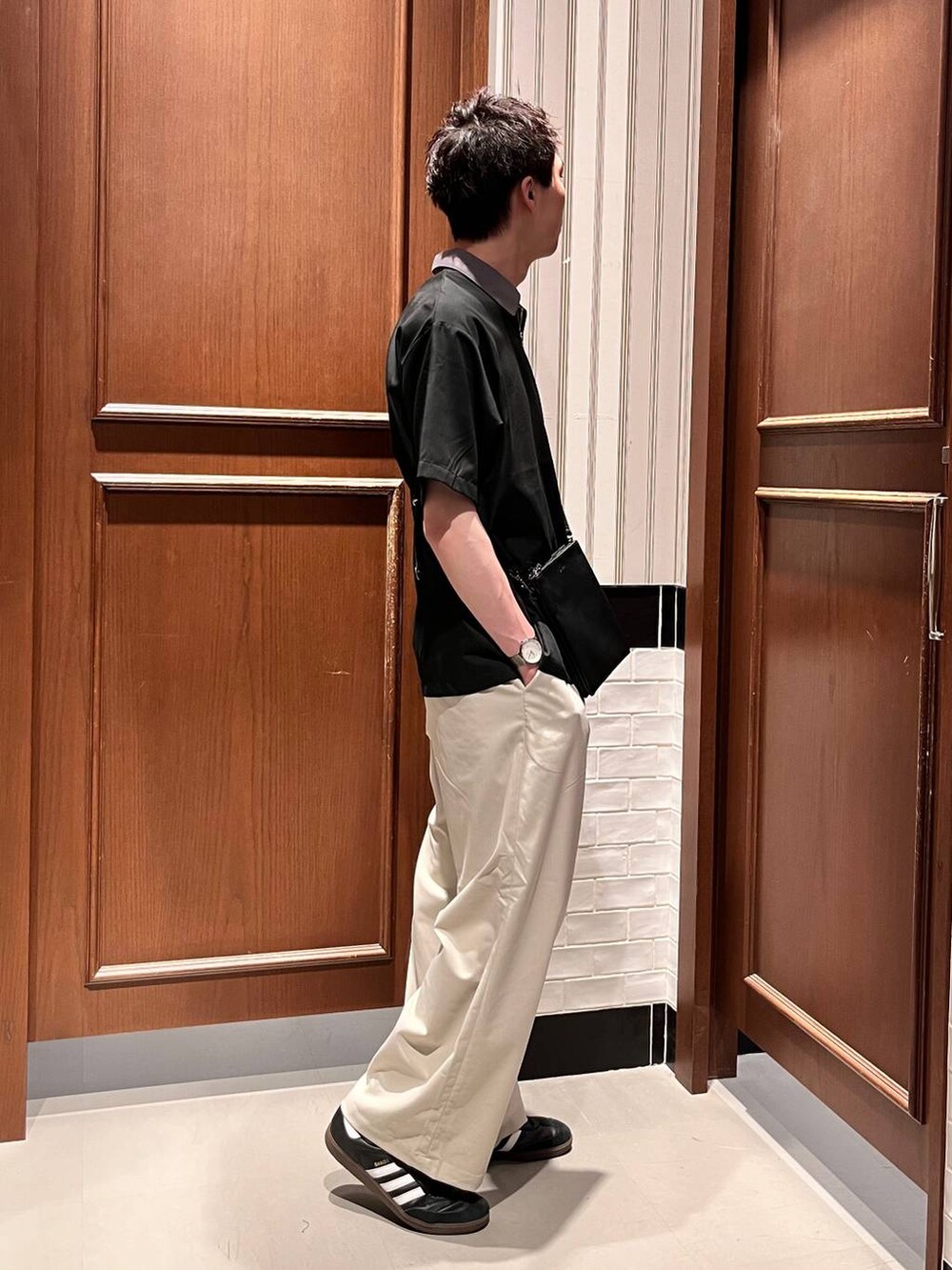 ホワイト系のスラックス、ブラック系のシャツ/ブラウス、ブラック系のショルダーバッグを着用したメンズの夏コーディネートの5枚目の写真