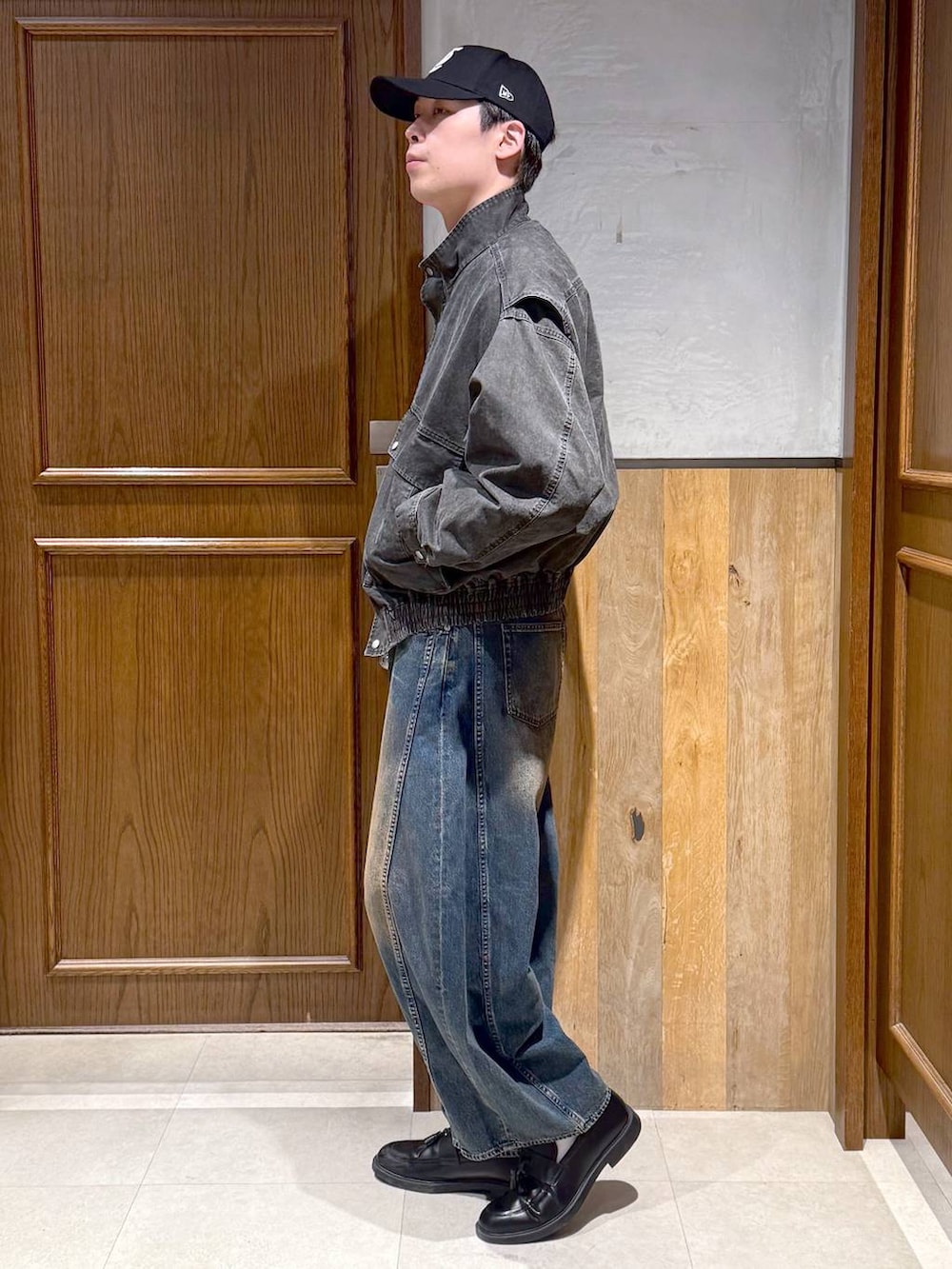 グレー系のスウェット、グレー系のブルゾン、ブルー系のデニムパンツを着用したメンズの春コーディネートの3枚目の写真