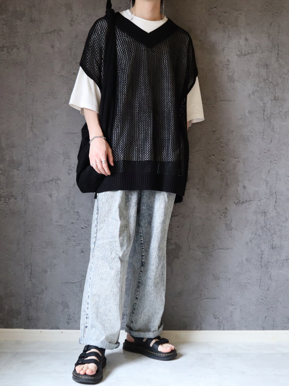 ブラック系のベスト、ホワイト系のTシャツ/カットソー、ブルー系のデニムパンツを着用したメンズの春コーディネートの2枚目の写真