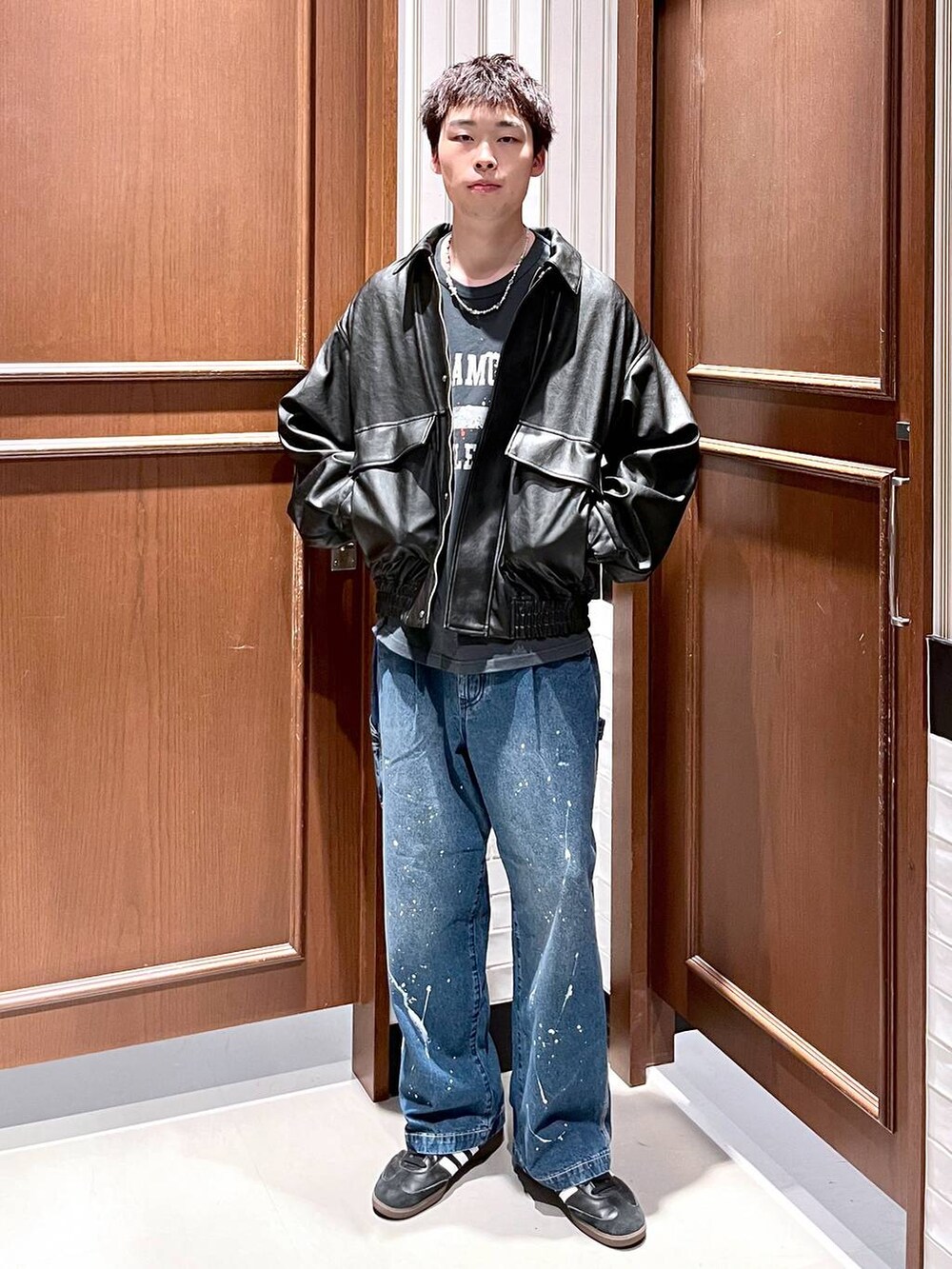 ブラック系のブルゾン、ブルー系のデニムパンツを着用したメンズの夏コーディネートの6枚目の写真