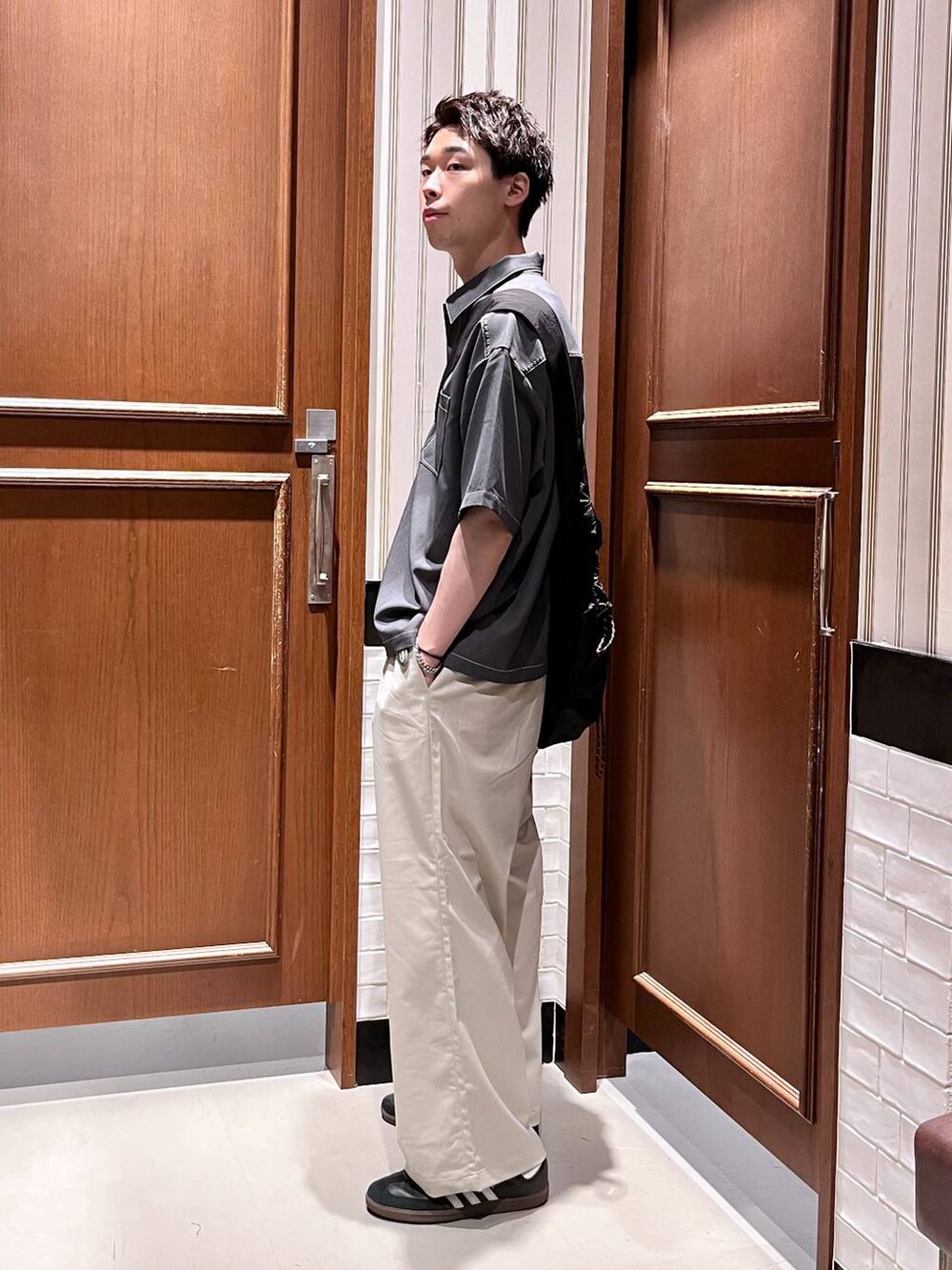 ホワイト系のスラックス、ブラック系のショルダーバッグ、グレー系のシャツ/ブラウスを着用したメンズの夏コーディネートの3枚目の写真