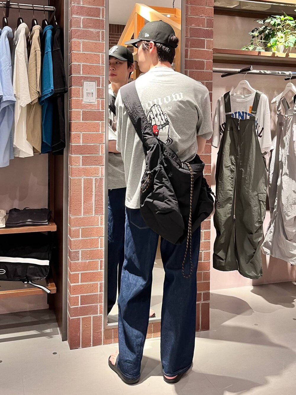 ブルー系のデニムパンツ、ブラック系のショルダーバッグ、グレー系のTシャツ/カットソーを着用したメンズの夏コーディネートの3枚目の写真