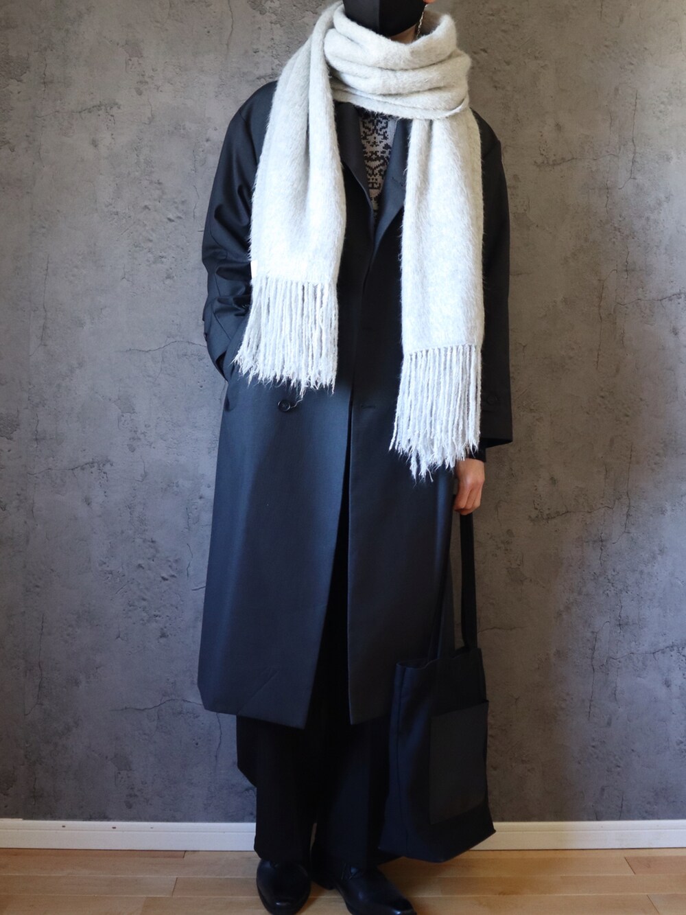 グレー系のニット/セーター、グレー系のトレンチコート、ブラック系のその他パンツを着用したメンズの冬コーディネートの2枚目の写真