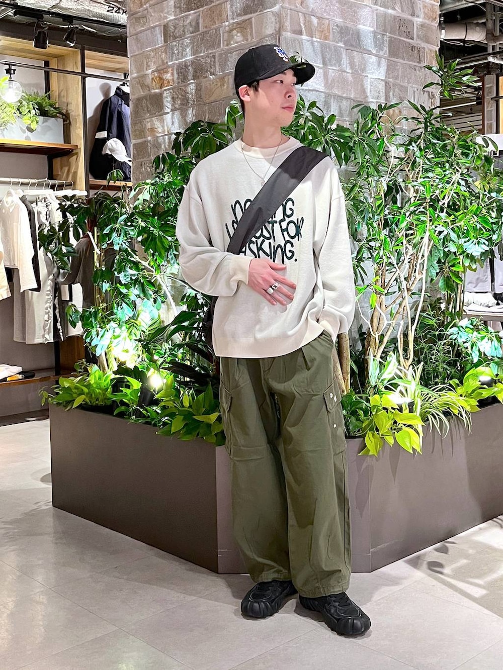 グリーン系のカーゴパンツ、その他のショルダーバッグ、ホワイト系のニット/セーターを着用したメンズの春コーディネートの2枚目の写真