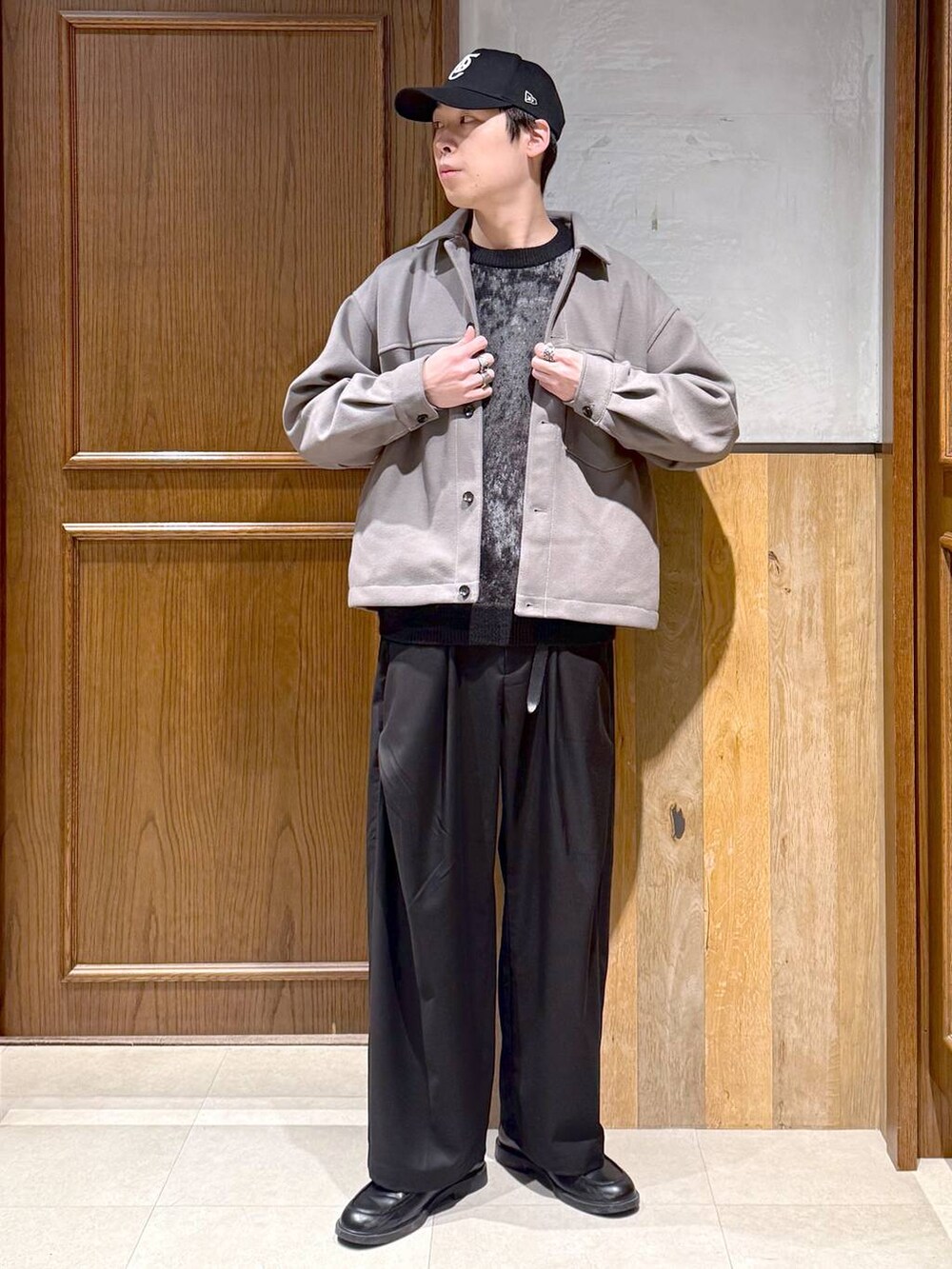 ベージュ系のブルゾン、ブラック系のニット/セーター、ブラック系のスラックスを着用したメンズの冬コーディネートの7枚目の写真