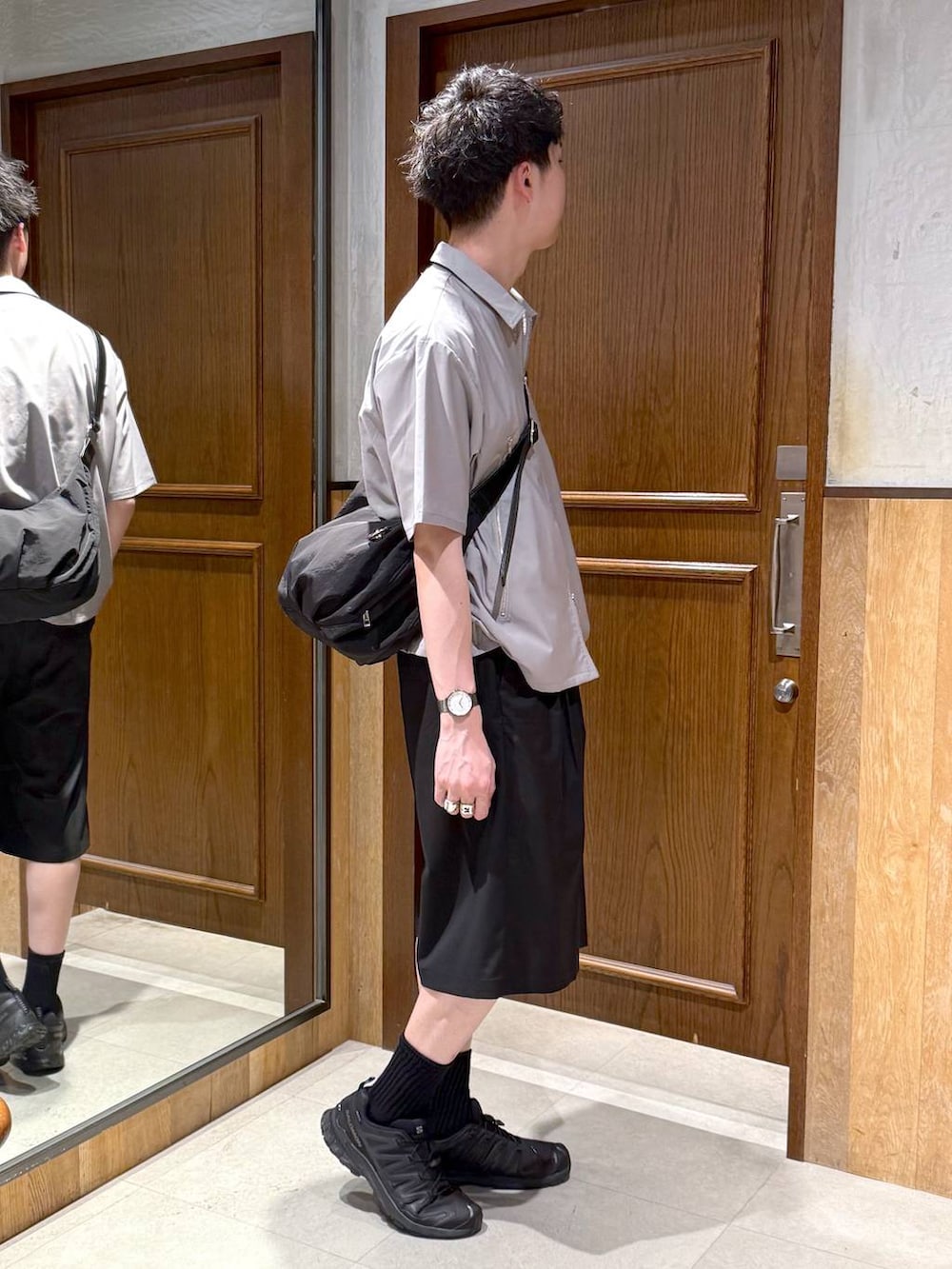 ブラック系のショルダーバッグ、ブラック系のスラックス、ホワイト系のTシャツ/カットソーを着用したメンズの春コーディネートの5枚目の写真