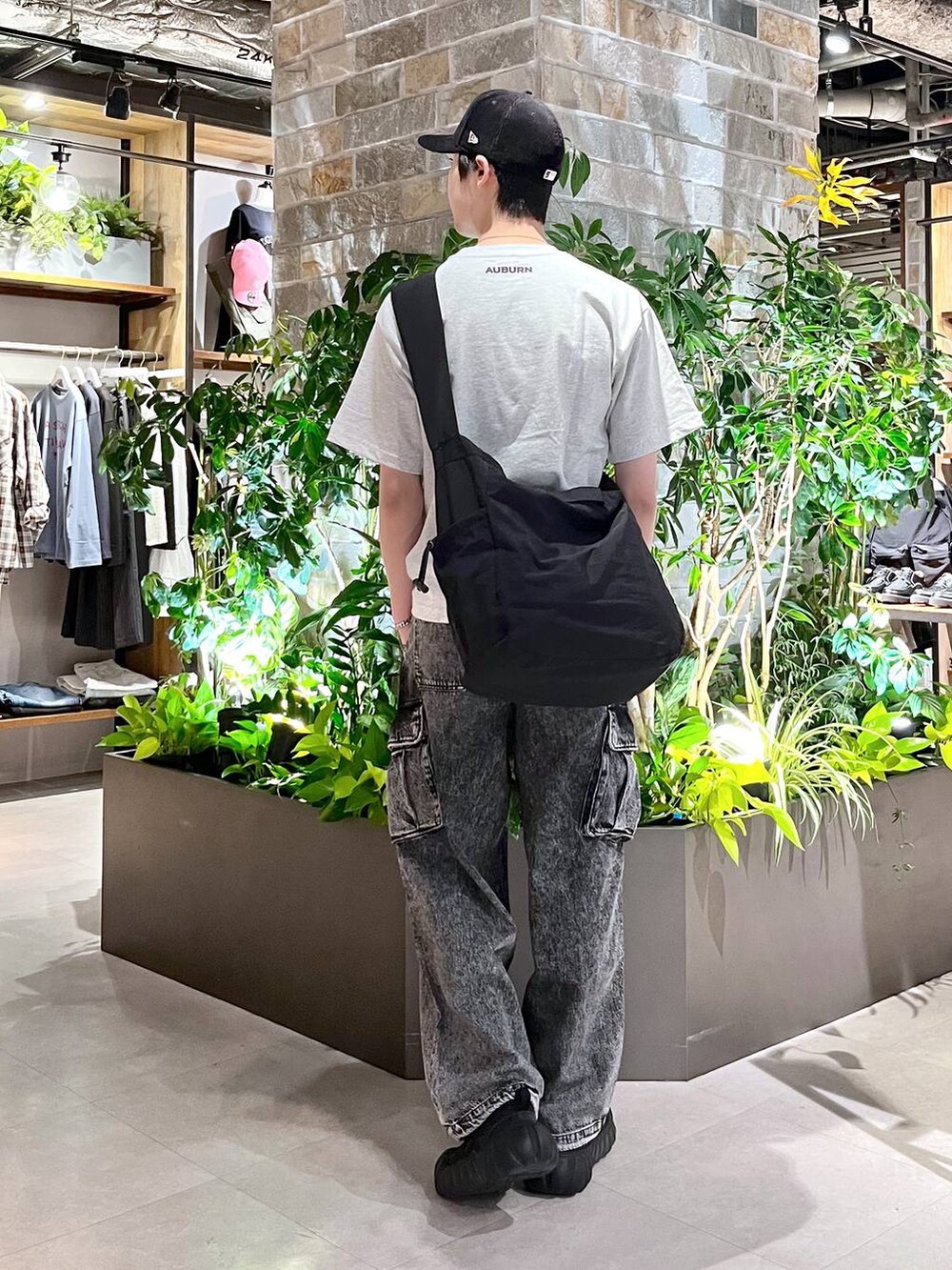 ブラック系のショルダーバッグ、グレー系のデニムパンツ、ホワイト系のTシャツ/カットソーを着用したメンズの春コーディネートの4枚目の写真