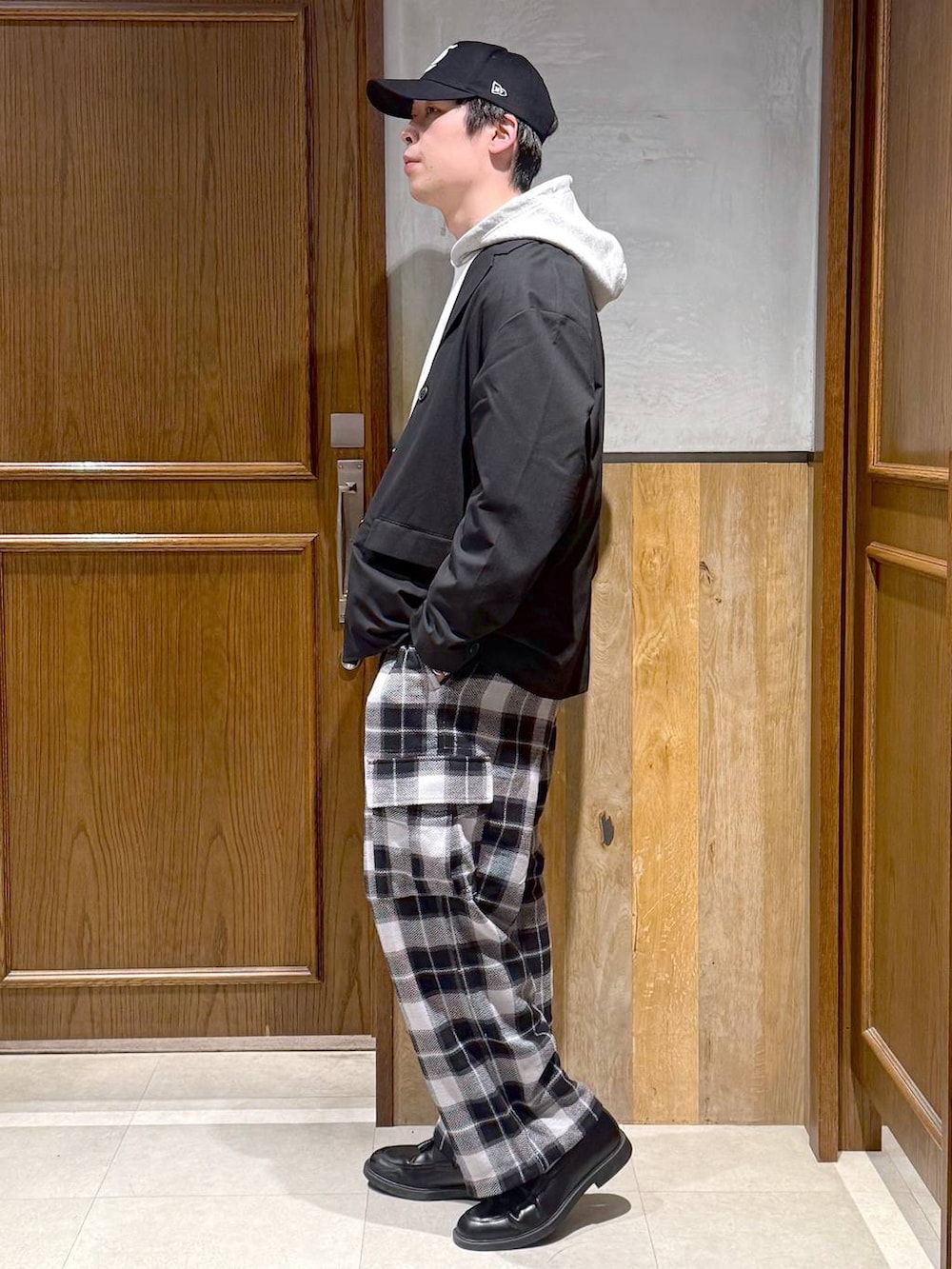 ブラック系のテーラードジャケット、グレー系のカーゴパンツ、グレー系のパーカーを着用したメンズの冬コーディネートの3枚目の写真