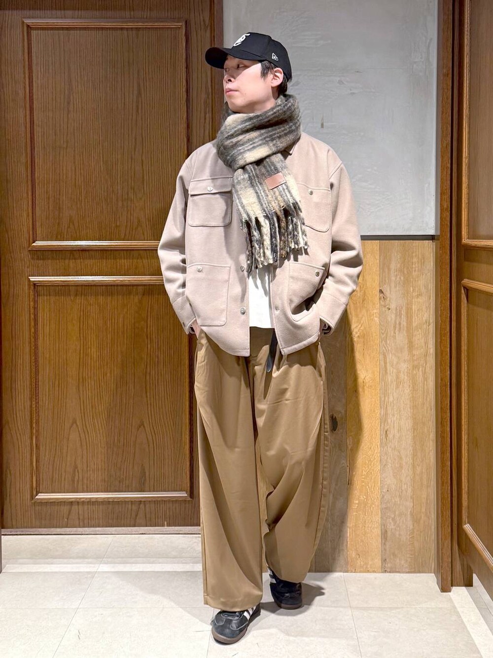 ホワイト系のニット/セーター、ベージュ系のブルゾン、ベージュ系のスラックスを着用したメンズの冬コーディネートの7枚目の写真