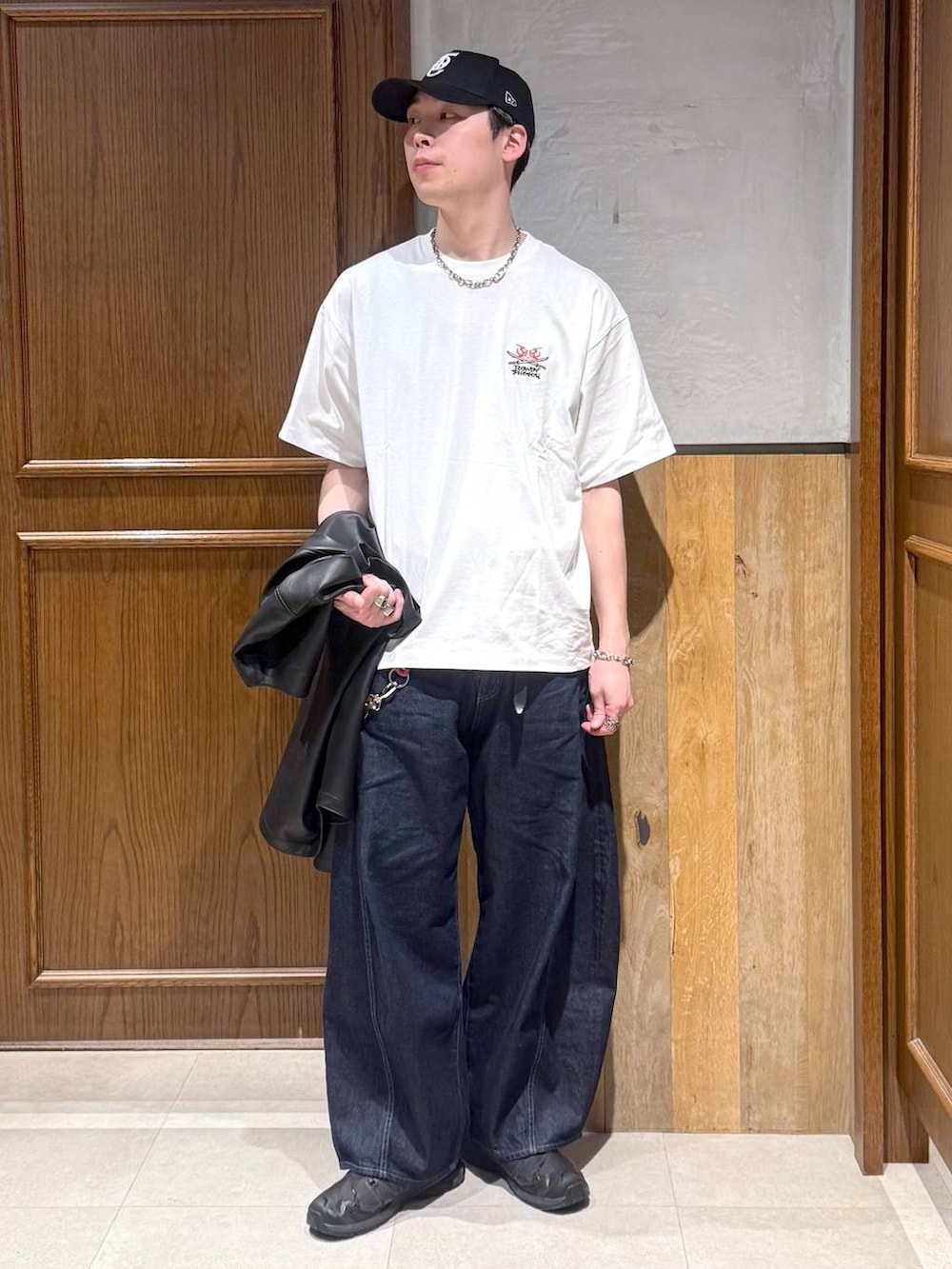 ホワイト系のTシャツ/カットソー、ブラック系のシャツ/ブラウス、ブルー系のデニムパンツを着用したメンズの春コーディネートの3枚目の写真