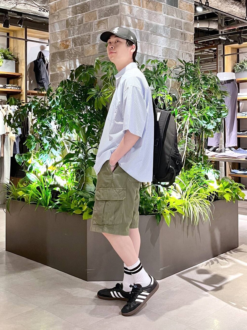 ブラック系のバックパック/リュック、ブルー系のシャツ/ブラウス、グリーン系のカーゴパンツを着用したメンズの夏コーディネートの3枚目の写真
