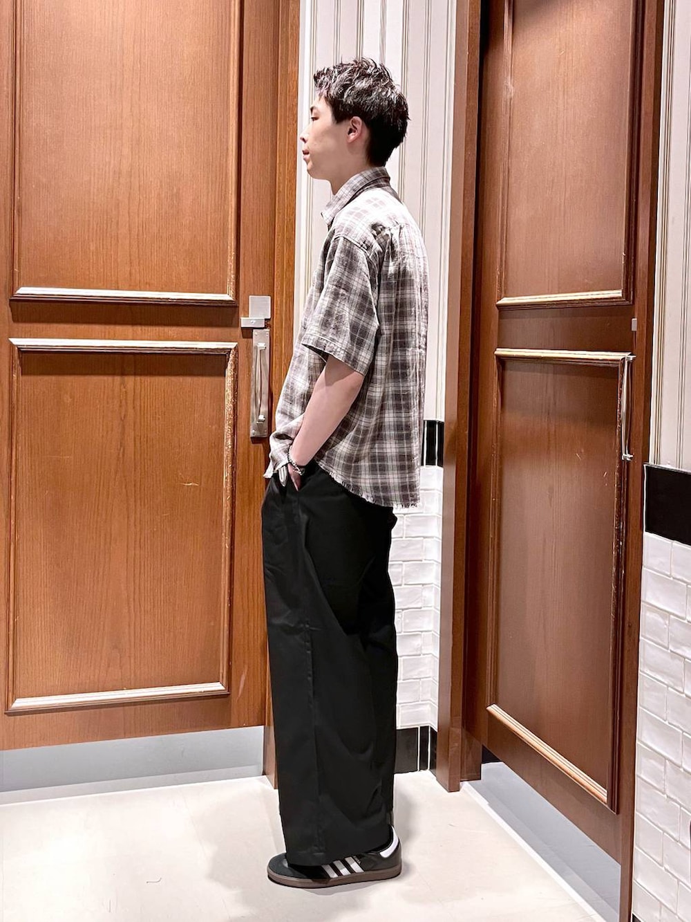 ブラック系のスラックス、グレー系のシャツ/ブラウスを着用したメンズの夏コーディネートの3枚目の写真