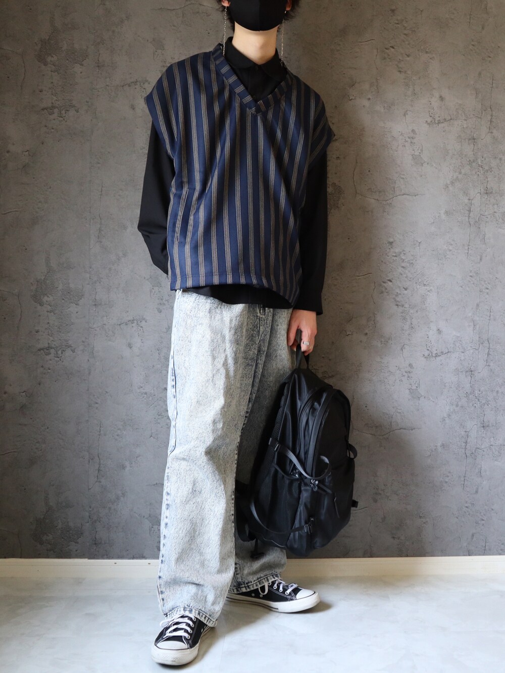 ブルー系のベスト、ブルー系のデニムパンツ、ブラック系のバックパック/リュックを着用したメンズの春コーディネートの4枚目の写真