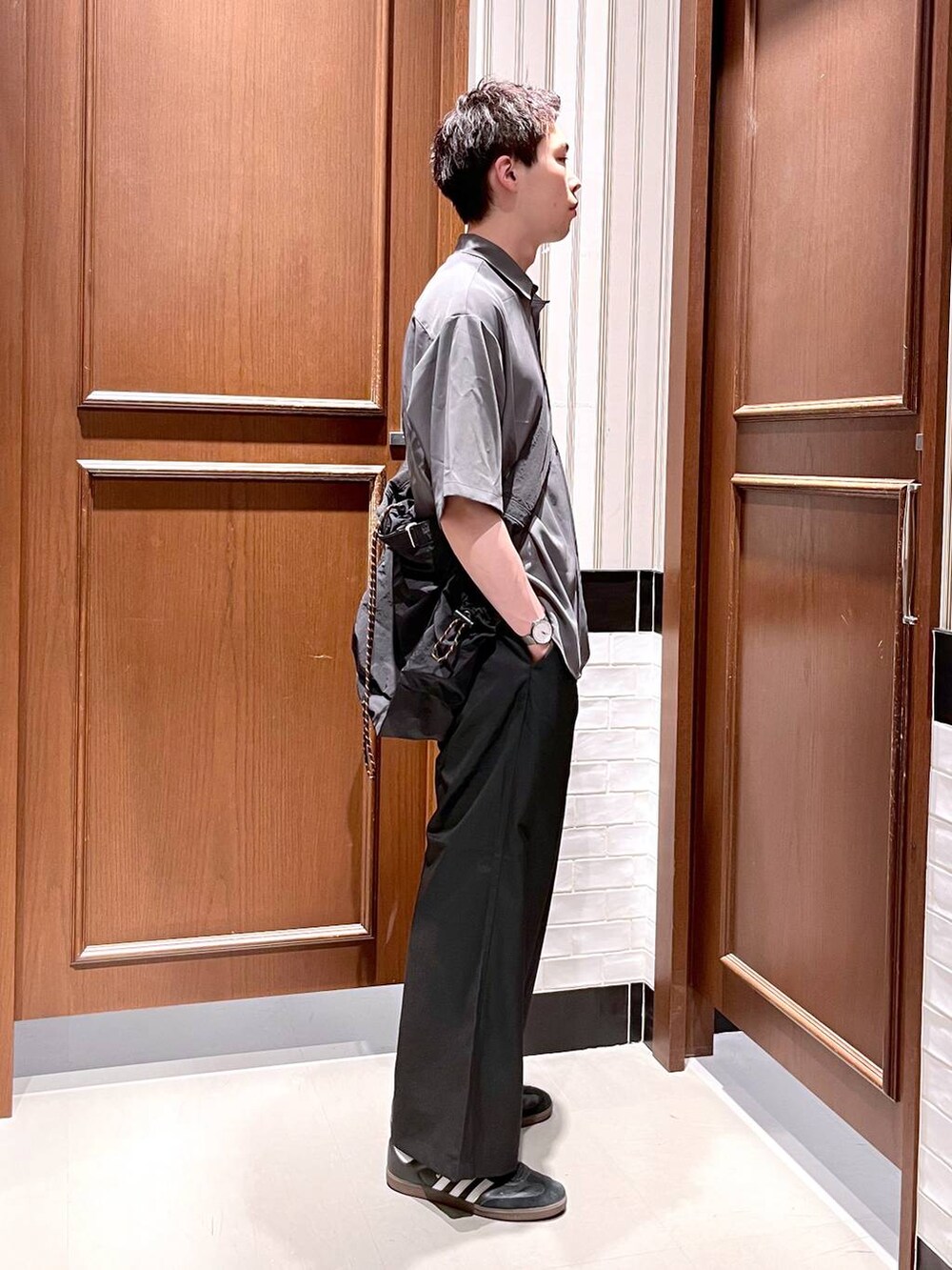 ブラック系のスラックス、グレー系のシャツ/ブラウス、ブラック系のショルダーバッグを着用したメンズの夏コーディネートの6枚目の写真