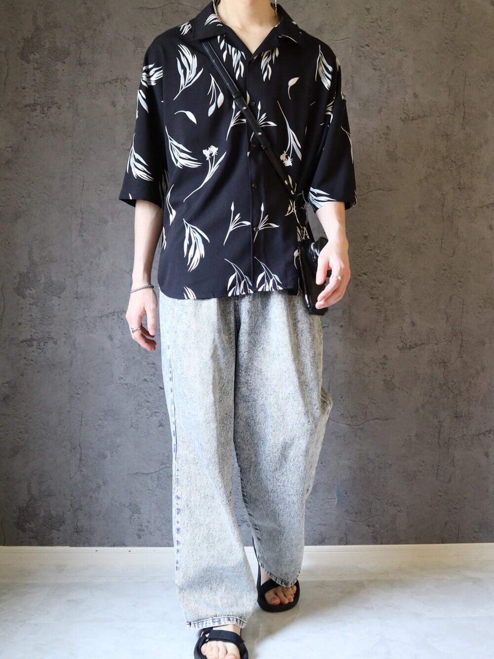 ブルー系のデニムパンツ、ブラック系のサンダル、ブラック系のシャツ/ブラウスを着用したメンズの春コーディネートの3枚目の写真