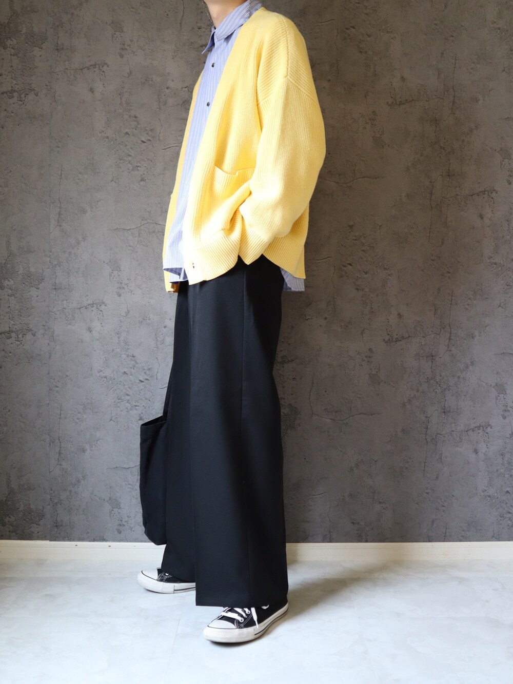 ブルー系のシャツ/ブラウス、イエロー系のニット/セーター、ブラック系のスラックスを着用したメンズの春コーディネートの3枚目の写真