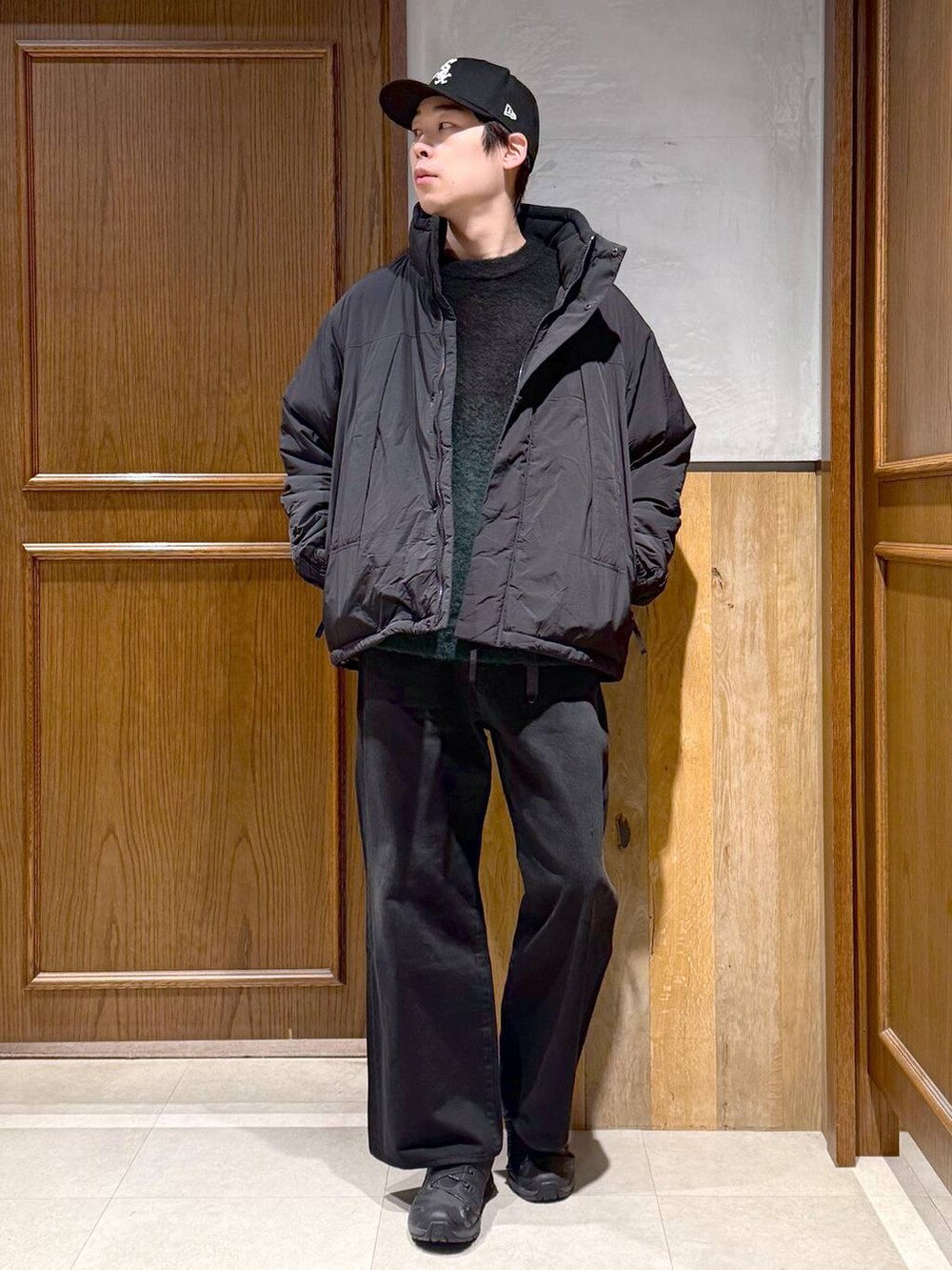 ブラック系のデニムパンツ、グリーン系のニット/セーター、ブラック系のダウンジャケット/コートを着用したメンズの冬コーディネートの4枚目の写真