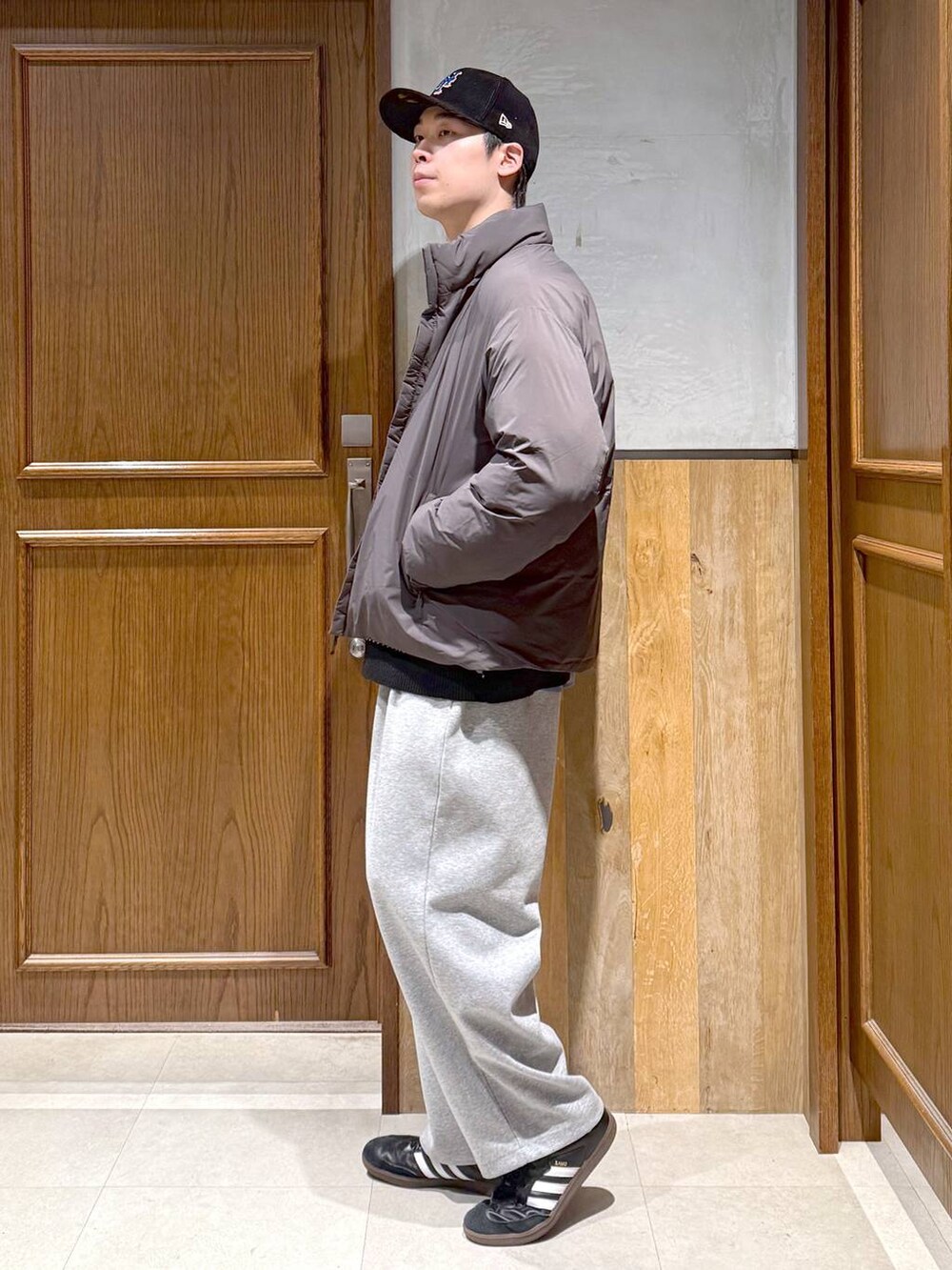 グレー系のダウンジャケット/コート、ブラック系のニット/セーター、グレー系のスウェットパンツを着用したメンズの秋コーディネートの5枚目の写真