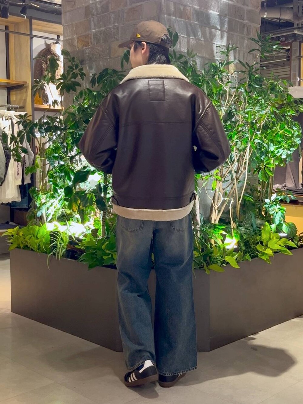 ブラウン系のムートンコート、ブルー系のデニムパンツ、ブルー系のデニムジャケットを着用したメンズの冬コーディネートの4枚目の写真