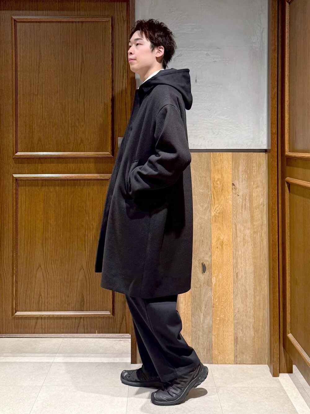 ブラック系のトレンチコート、ブルー系のシャツ/ブラウス、ブラック系のパーカーを着用したメンズの秋コーディネートの4枚目の写真