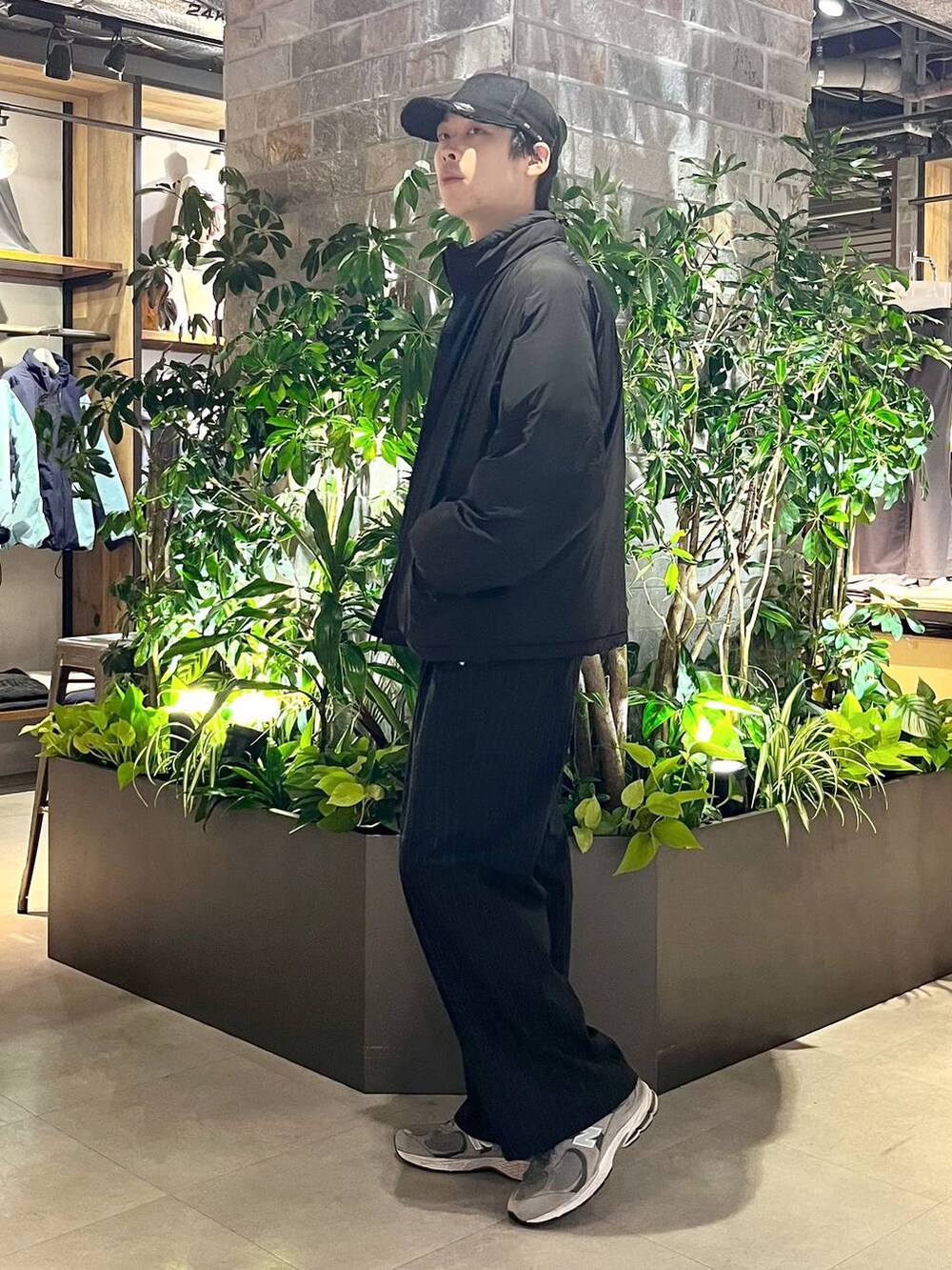 ブラック系のダウンジャケット/コート、ブラック系のスラックス、その他のスウェットを着用したメンズの冬コーディネートの3枚目の写真