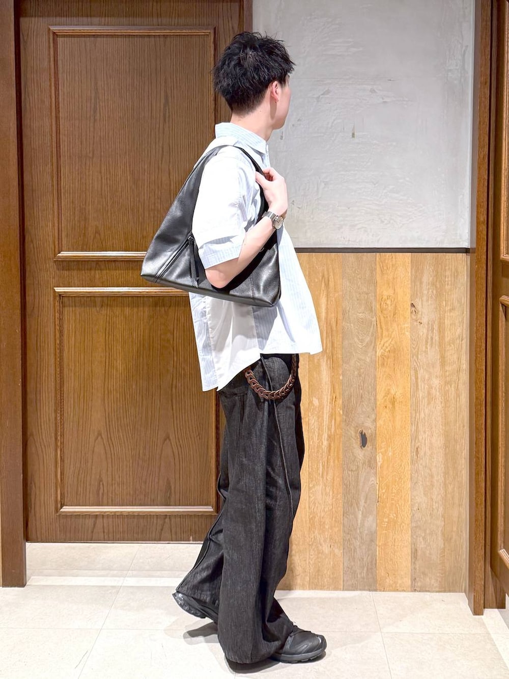 ブラック系のトートバッグ、ブラック系のデニムパンツ、ホワイト系のシャツ/ブラウスを着用したメンズの春コーディネートの5枚目の写真