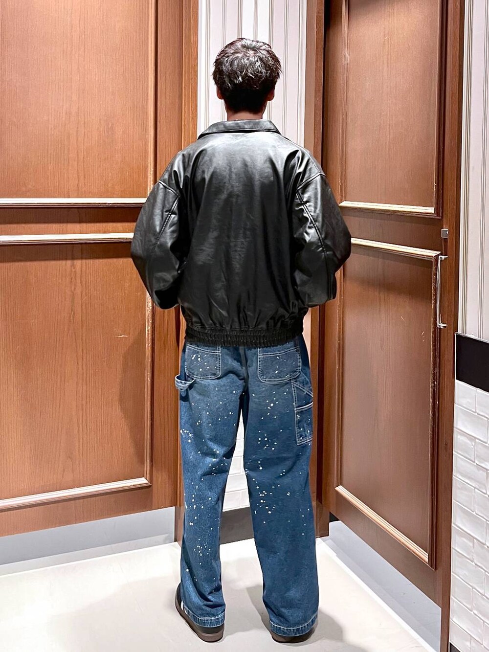 ブラック系のブルゾン、ブルー系のデニムパンツを着用したメンズの夏コーディネートの4枚目の写真